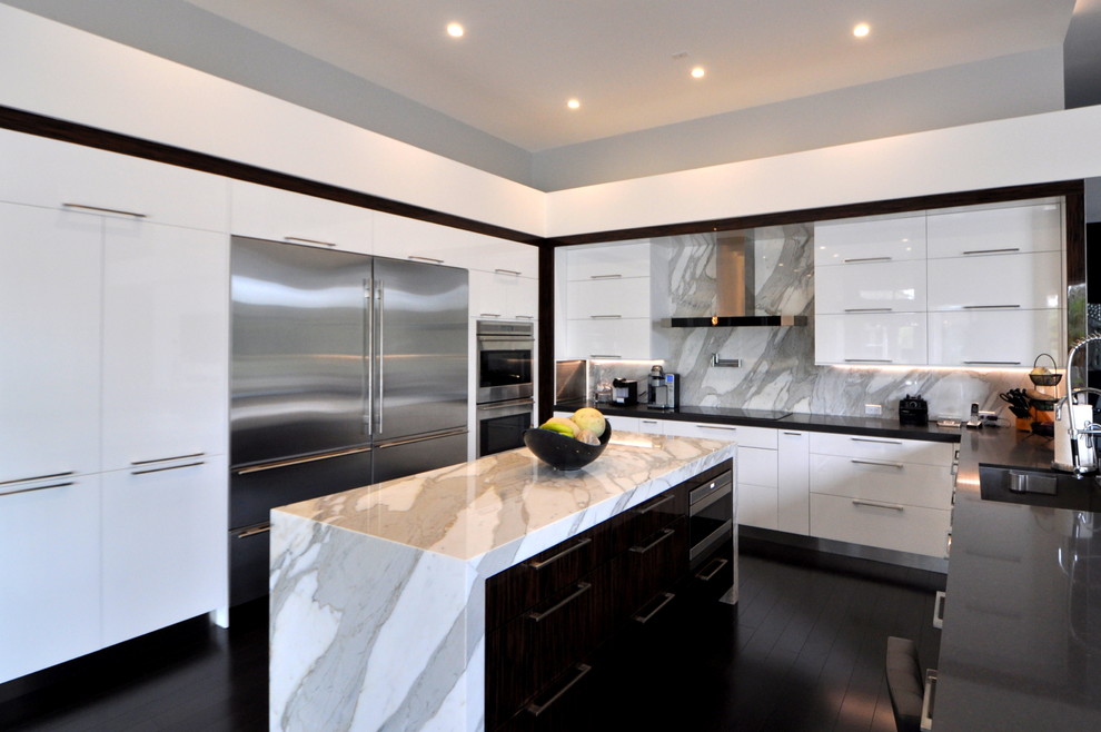 Inspiration for a large modern kitchen in Miami with an undermount sink, flat-panel cabinets, white cabinets, marble benchtops, grey splashback, stone slab splashback, stainless steel appliances, dark hardwood floors and with island.