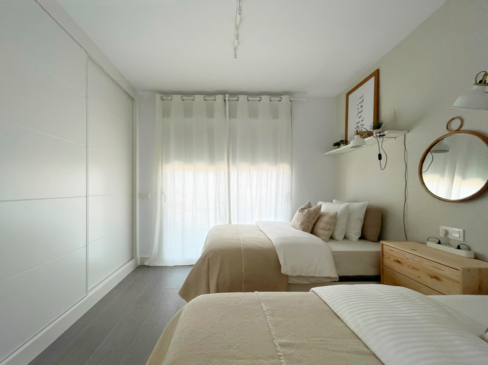 Ispirazione per una camera degli ospiti mediterranea di medie dimensioni con pareti beige, pavimento con piastrelle in ceramica, pavimento grigio e carta da parati