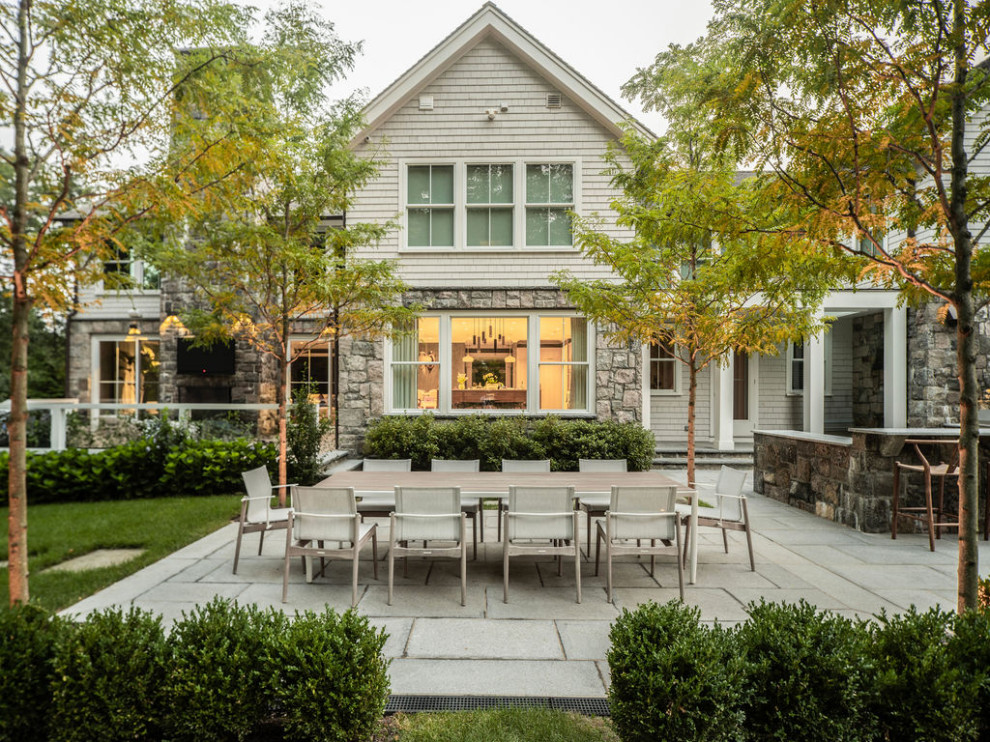 Large trendy backyard stone and rectangular infinity pool photo in New York