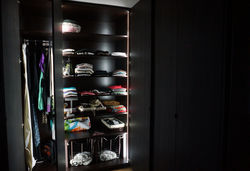 This is an example of a large contemporary dressing room in Miami with flat-panel cabinets, dark wood cabinets and bamboo floors.