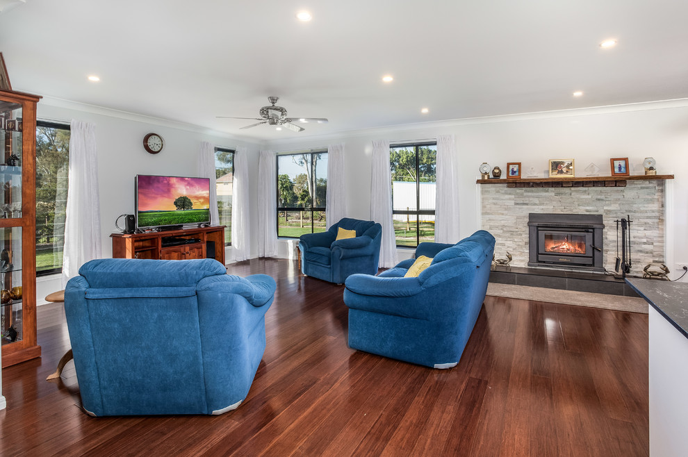 This is an example of a small transitional enclosed family room in Brisbane with grey walls, bamboo floors, a standard fireplace and a stone fireplace surround.