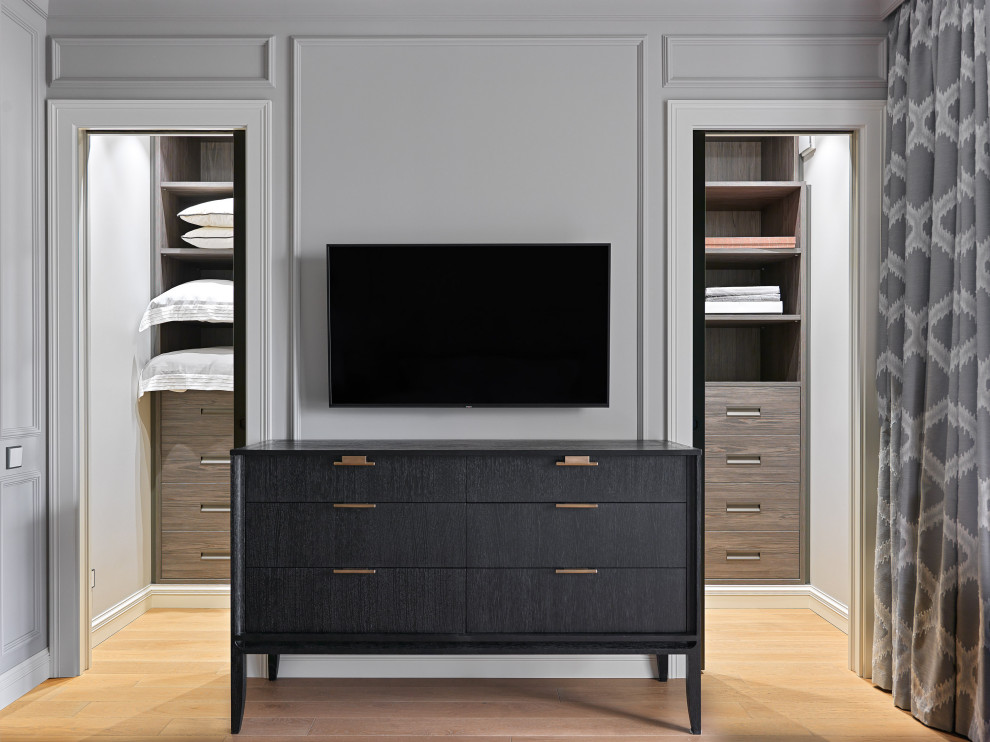 Transitional gender-neutral walk-in wardrobe in Moscow with flat-panel cabinets, dark wood cabinets and brown floor.