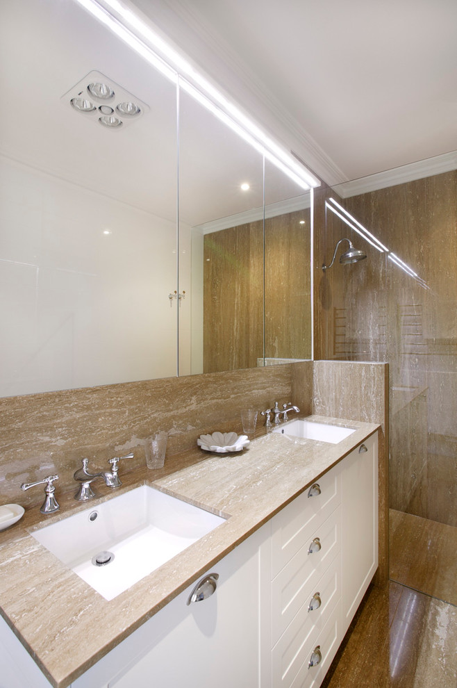 Photo of a mid-sized contemporary master wet room bathroom in Sydney with shaker cabinets, white cabinets, a wall-mount toilet, beige tile, marble, beige walls, an undermount sink and marble benchtops.