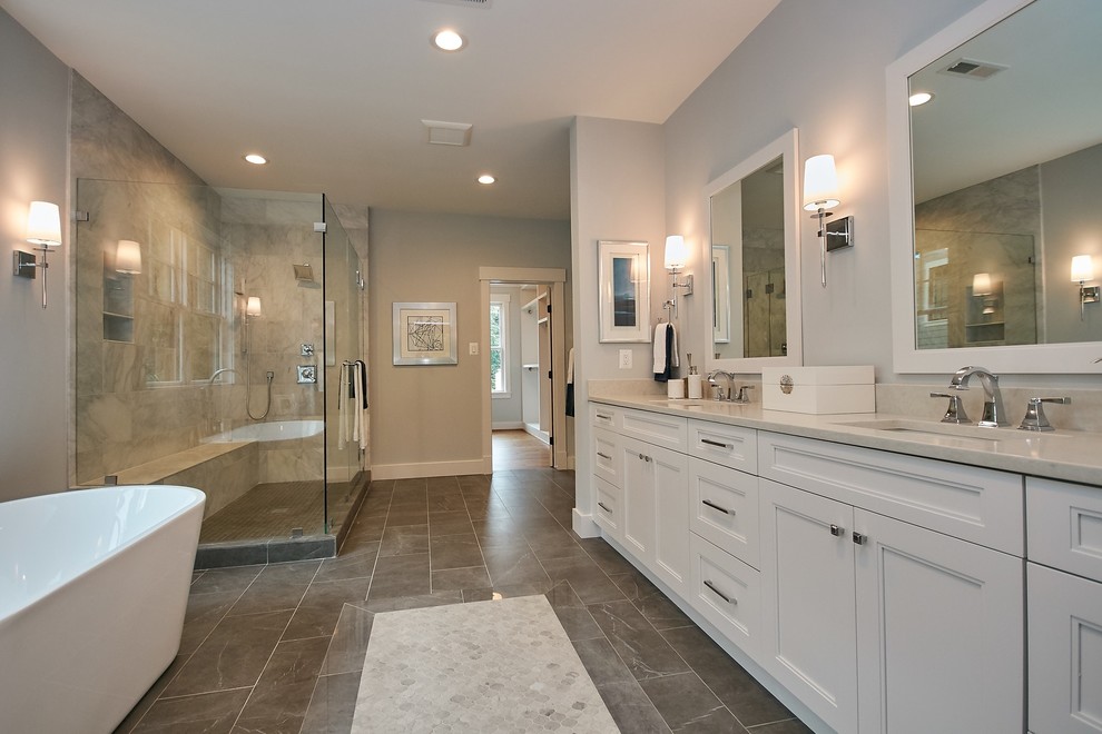 Photo of a large country master bathroom in DC Metro with recessed-panel cabinets, white cabinets, a freestanding tub, a double shower, a two-piece toilet, white tile, marble, grey walls, ceramic floors, an undermount sink, engineered quartz benchtops, grey floor, a hinged shower door and grey benchtops.