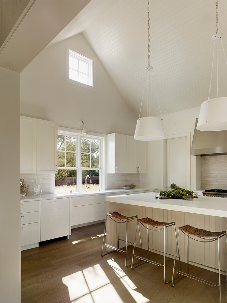 Photo of a large transitional u-shaped separate kitchen in San Francisco with white cabinets, beige splashback and with island.