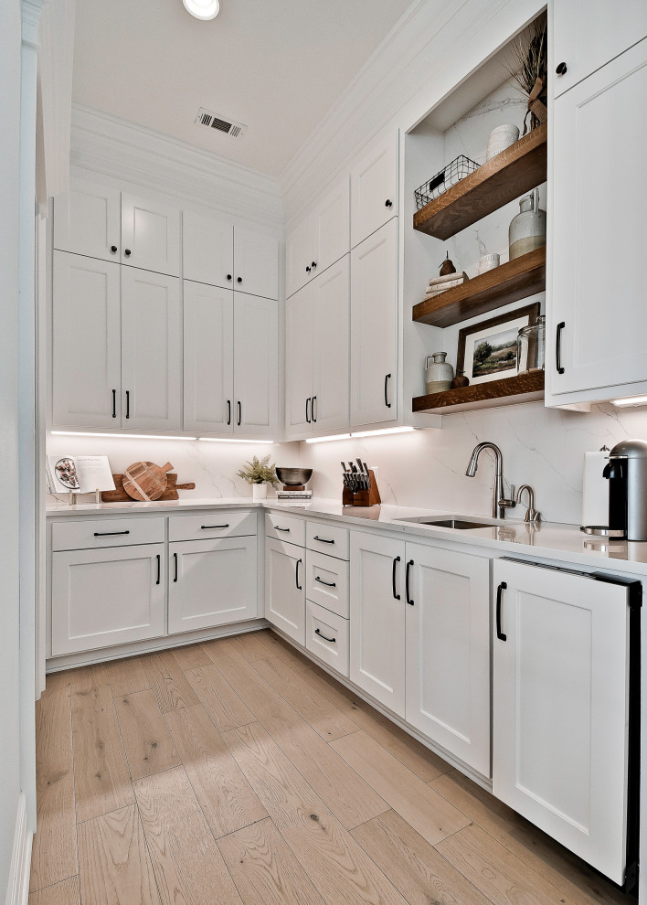 Inspiration for a large arts and crafts kitchen in Other with raised-panel cabinets, white cabinets, quartzite benchtops, white splashback, engineered quartz splashback, stainless steel appliances, light hardwood floors, with island and white benchtop.