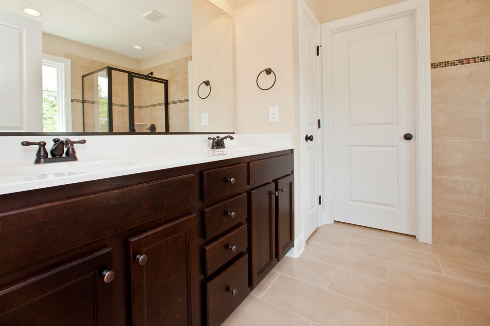Design ideas for a mid-sized traditional master bathroom in Raleigh with an integrated sink, dark wood cabinets, marble benchtops, a drop-in tub, an open shower, a two-piece toilet, beige tile, ceramic tile, beige walls, ceramic floors, recessed-panel cabinets, beige floor and a hinged shower door.