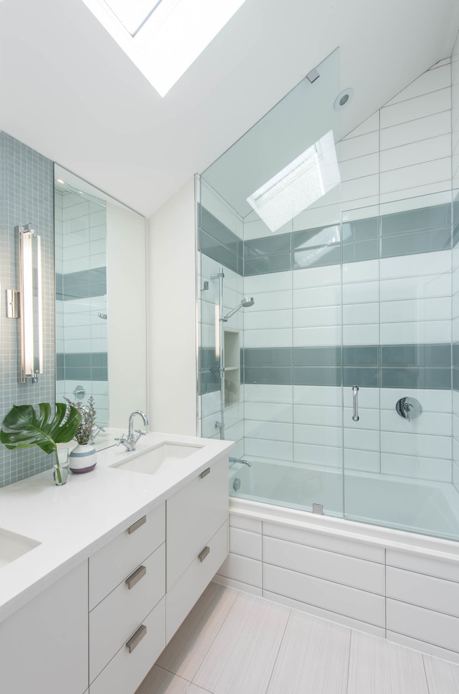 Mid-sized contemporary bathroom in Toronto with an undermount sink, flat-panel cabinets, white cabinets, quartzite benchtops, an alcove tub, a shower/bathtub combo, white tile, gray tile, porcelain tile, white walls, porcelain floors and white benchtops.
