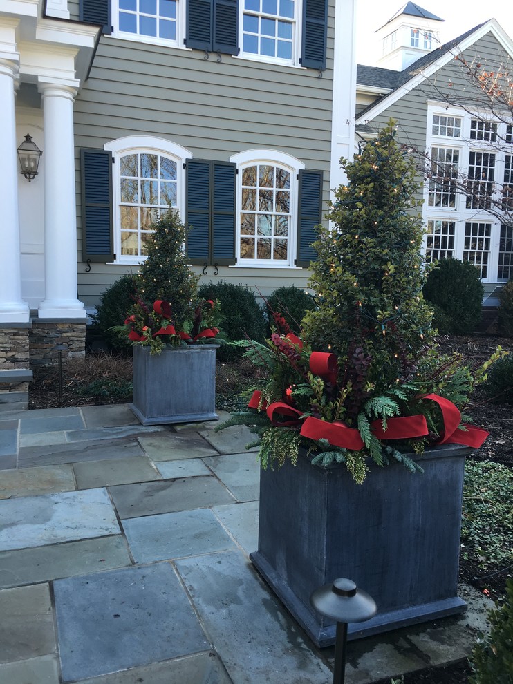 This is an example of a traditional front yard full sun formal garden for winter in New York with a container garden and natural stone pavers.