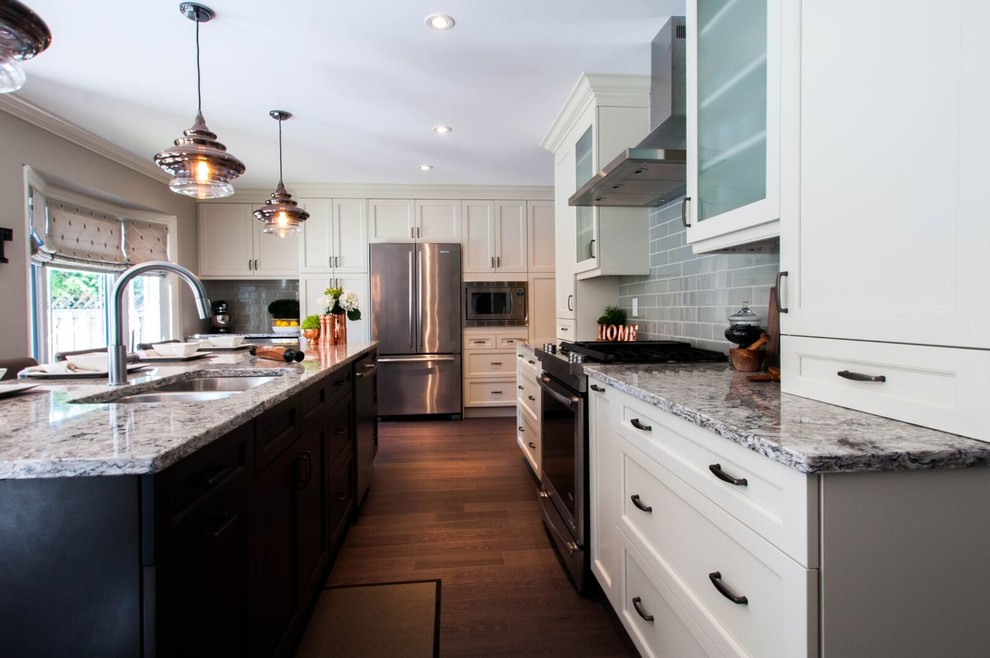 Large transitional l-shaped kitchen in Toronto with an undermount sink, shaker cabinets, grey cabinets, quartzite benchtops, grey splashback, glass tile splashback, stainless steel appliances, medium hardwood floors and with island.