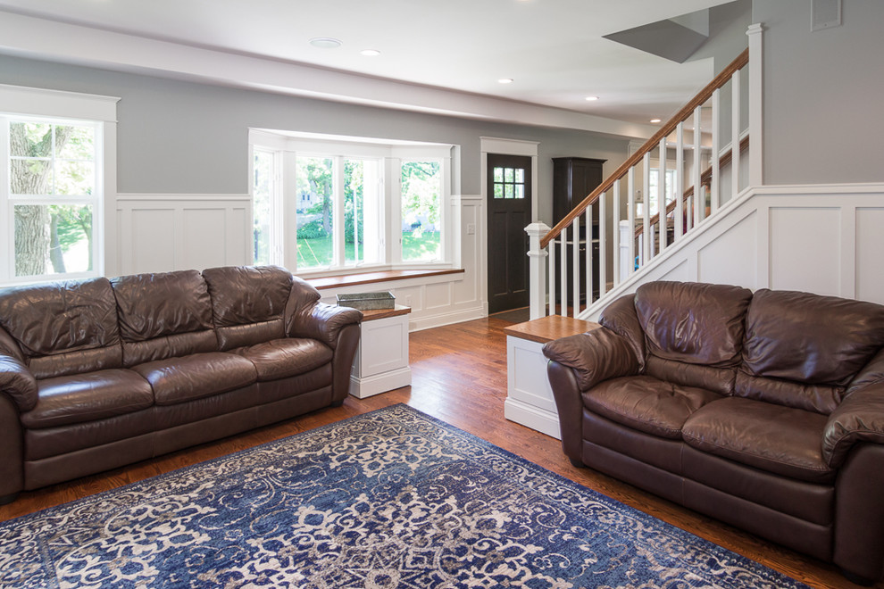 Example of a large transitional medium tone wood floor and brown floor front door design in Minneapolis with gray walls and a dark wood front door
