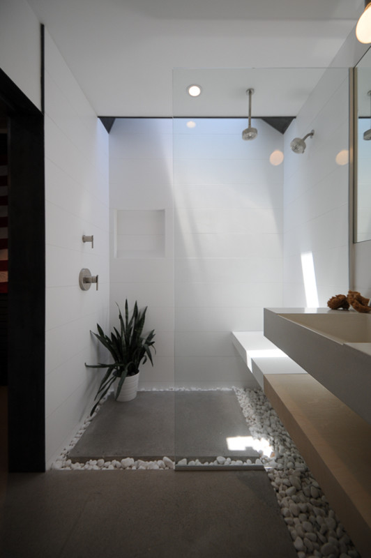 This is an example of a small modern 3/4 bathroom in Phoenix with a trough sink, open cabinets, light wood cabinets, concrete benchtops, a curbless shower, white tile, white walls and concrete floors.