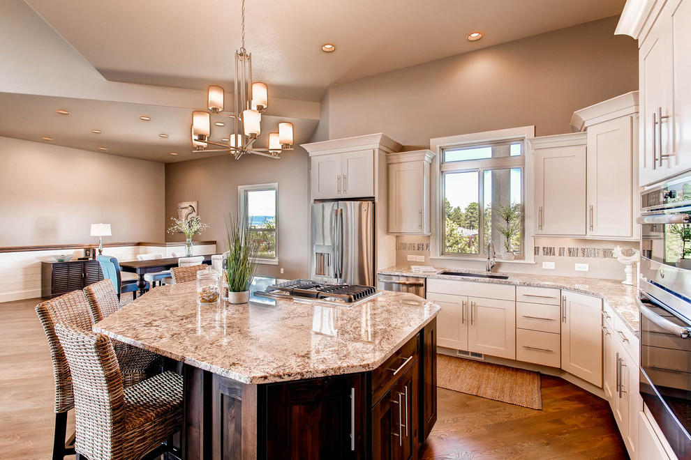 Inspiration for a large transitional single-wall open concept kitchen remodel in Denver with a drop-in sink, shaker cabinets, white cabinets, multicolored backsplash, stainless steel appliances and an island