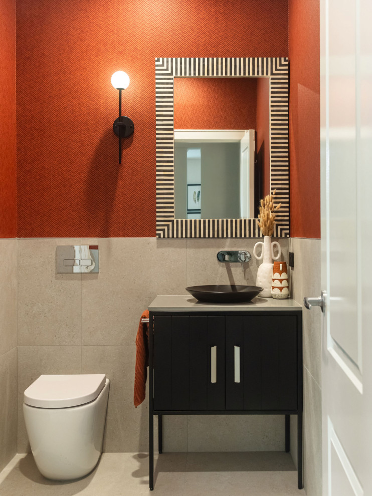 Exemple d'un WC et toilettes tendance de taille moyenne avec un carrelage beige, des carreaux de porcelaine, un mur orange, un sol en carrelage de porcelaine, un plan vasque, un plan de toilette en quartz modifié, un sol beige, un plan de toilette gris, meuble-lavabo sur pied et du papier peint.