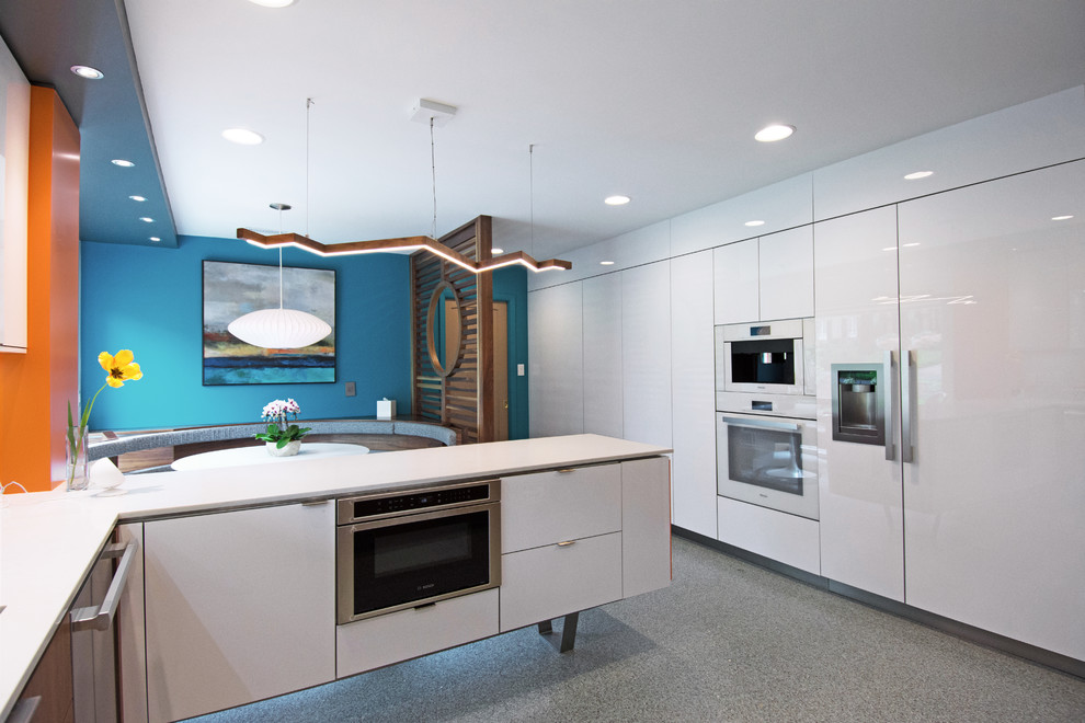 Mid-sized midcentury l-shaped eat-in kitchen in Charlotte with an undermount sink, flat-panel cabinets, white cabinets, quartzite benchtops, white splashback, white appliances, terrazzo floors, with island, grey floor and white benchtop.