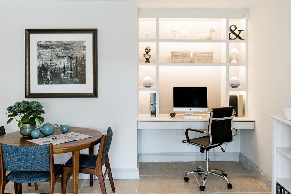 Photo of a small modern home office in Gloucestershire with white walls, a built-in desk and grey floor.
