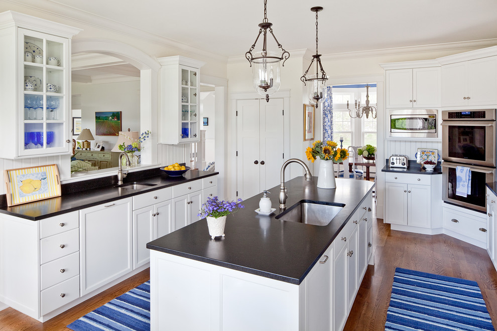 Photo of a traditional separate kitchen in Portland Maine with an undermount sink, shaker cabinets, white cabinets and panelled appliances.
