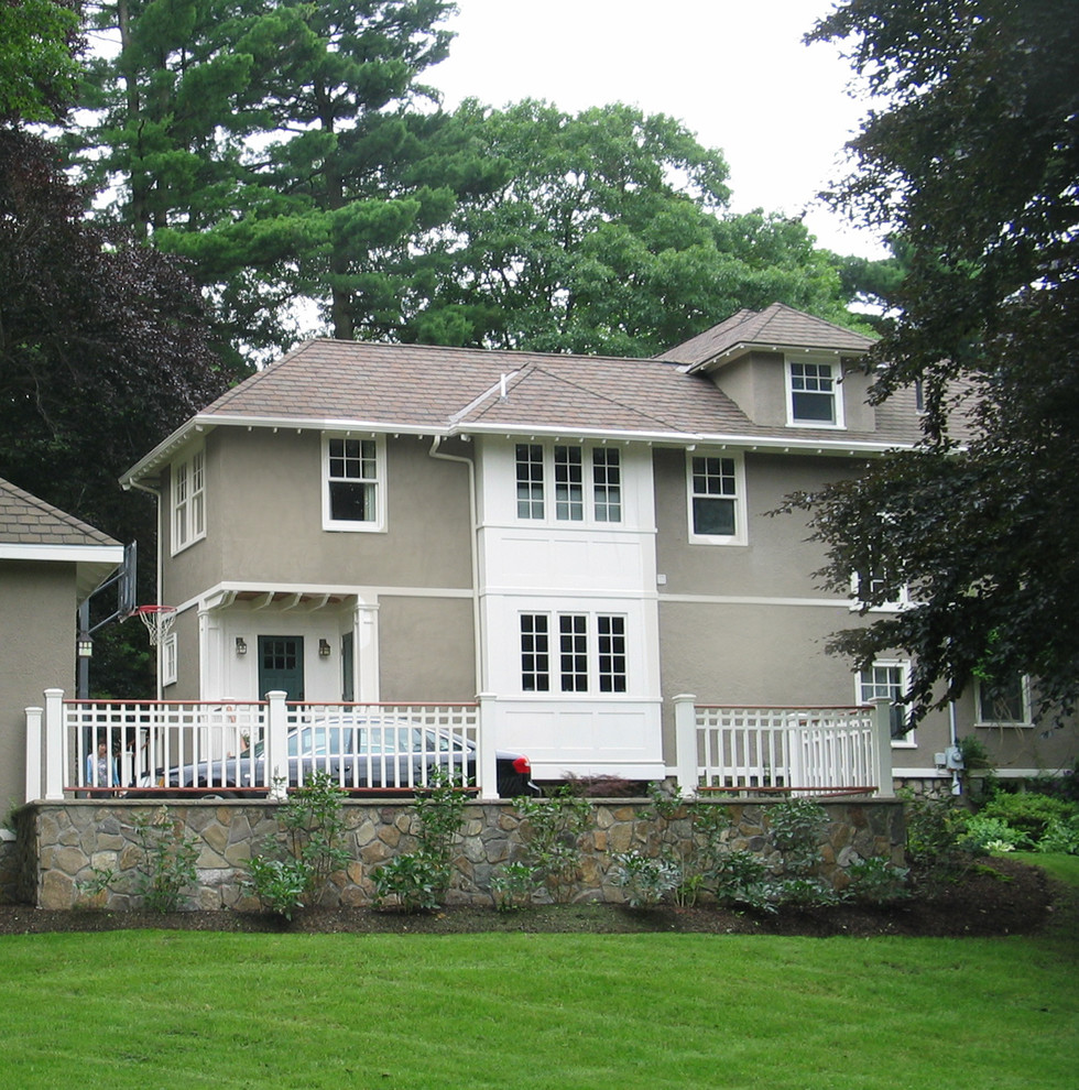 Arts and crafts two-storey stucco grey exterior in Boston with a gable roof.
