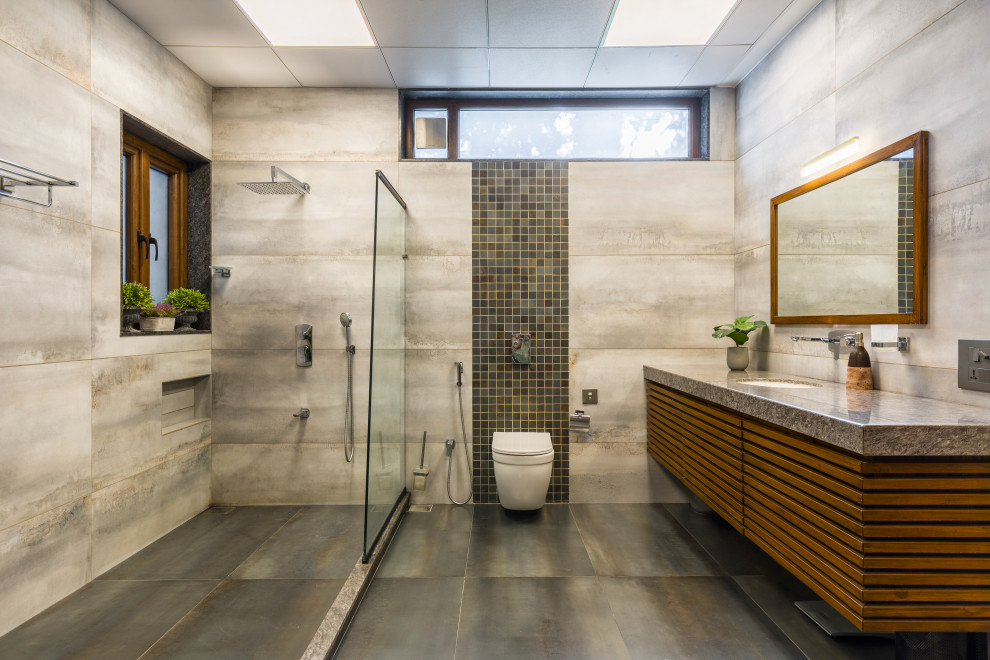 Exempel på ett modernt grå grått badrum, med släta luckor, skåp i mellenmörkt trä, grå väggar, ett undermonterad handfat och grått golv