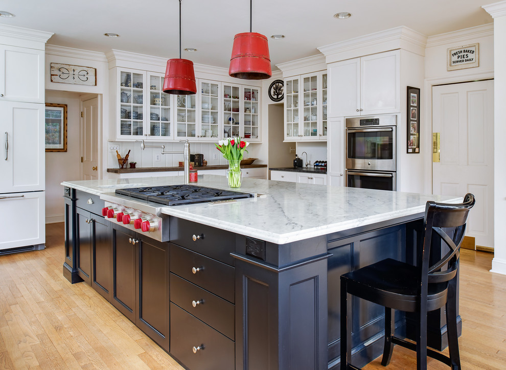 Inspiration for a transitional l-shaped kitchen in DC Metro with an integrated sink, shaker cabinets, blue cabinets, white splashback, stainless steel appliances, medium hardwood floors and with island.