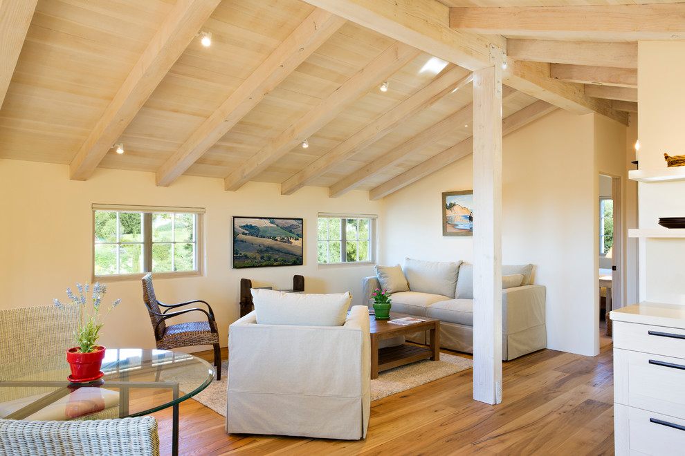 Mediterranean open concept family room in Santa Barbara with beige walls and light hardwood floors.