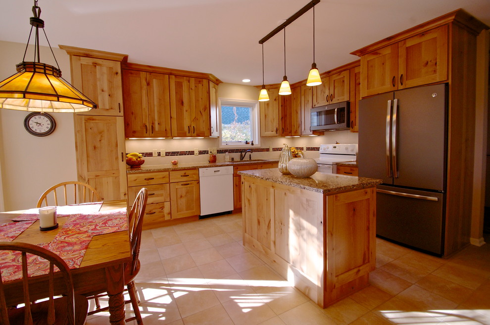 Example of a transitional l-shaped porcelain tile eat-in kitchen design with an undermount sink, flat-panel cabinets, light wood cabinets, quartz countertops, beige backsplash, ceramic backsplash, white appliances and an island