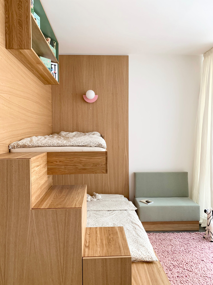 Photo of a small contemporary kids' bedroom for girls in Berlin with white walls, concrete flooring, grey floors and wood walls.