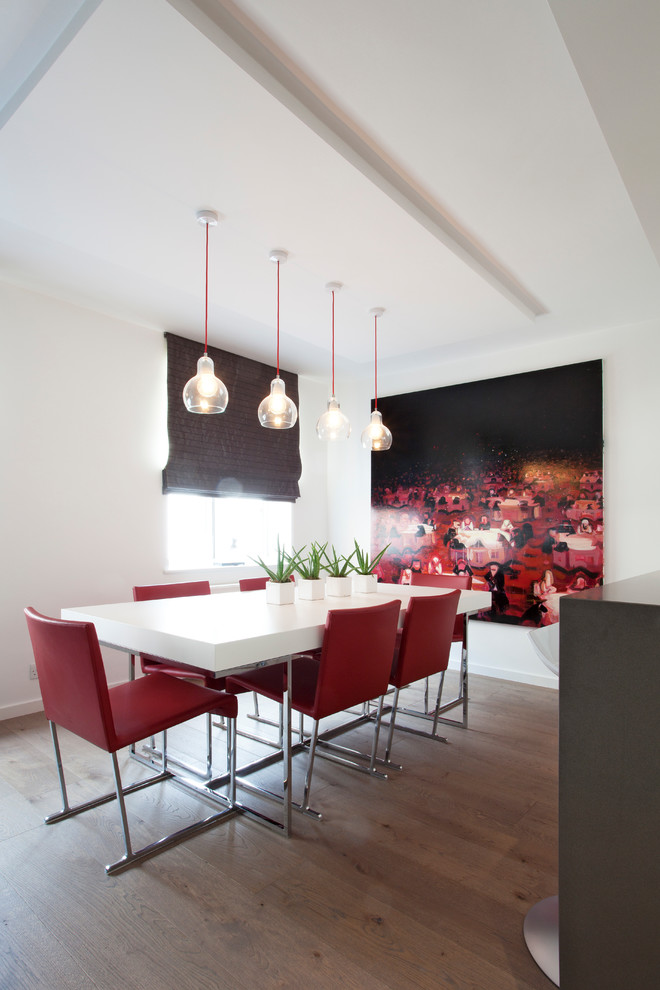 Design ideas for a mid-sized modern separate dining room in London with white walls and medium hardwood floors.