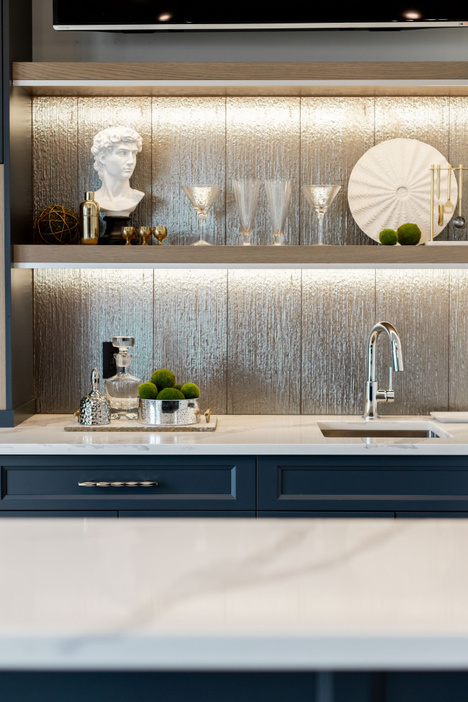 This is an example of a small transitional wet bar in Vancouver with an undermount sink, shaker cabinets, blue cabinets, quartzite benchtops, grey splashback, ceramic splashback, light hardwood floors, brown floor and multi-coloured benchtop.