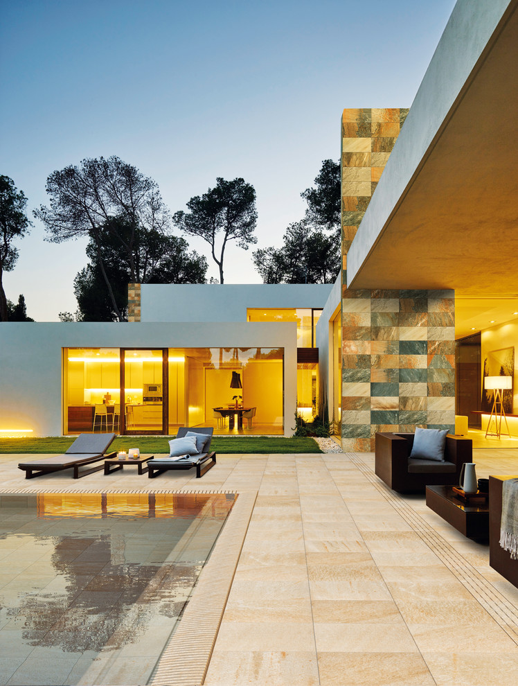 Large contemporary two-storey beige exterior in Barcelona with stone veneer and a flat roof.