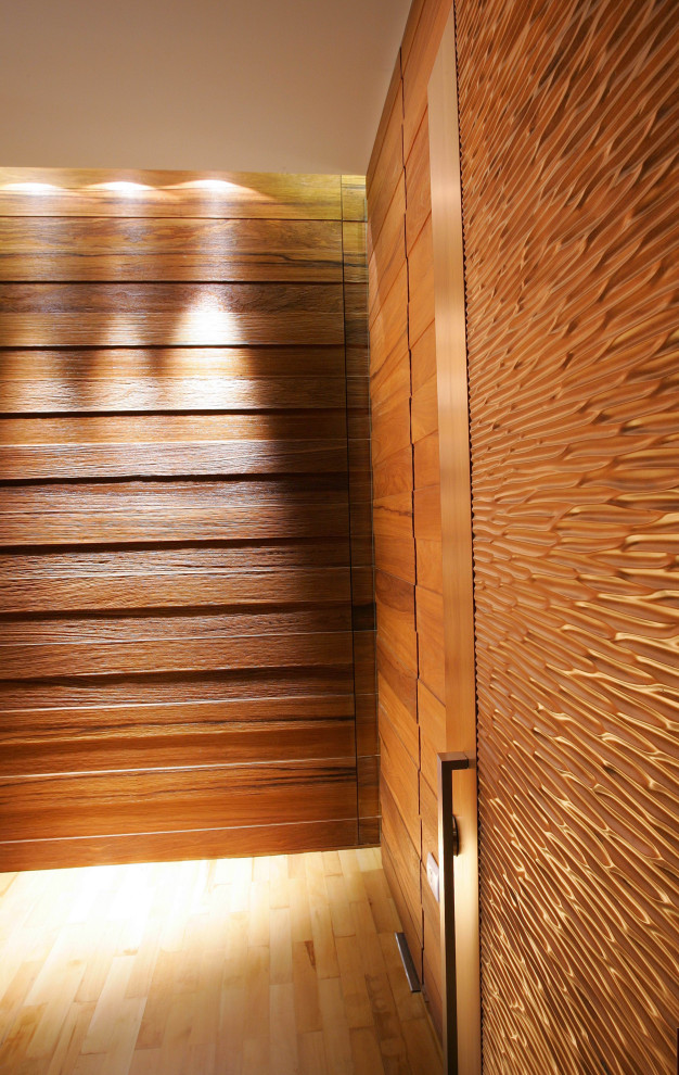 Ispirazione per un ingresso moderno di medie dimensioni con pavimento in legno massello medio, una porta a pivot, una porta in legno bruno, pareti in legno e pavimento beige