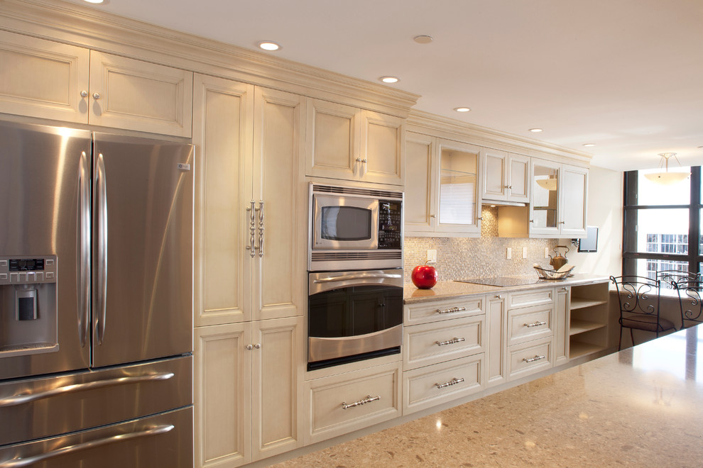 Inspiration for a large transitional galley eat-in kitchen remodel in Miami with recessed-panel cabinets, beige cabinets, granite countertops, multicolored backsplash, mosaic tile backsplash, stainless steel appliances, an island and beige countertops