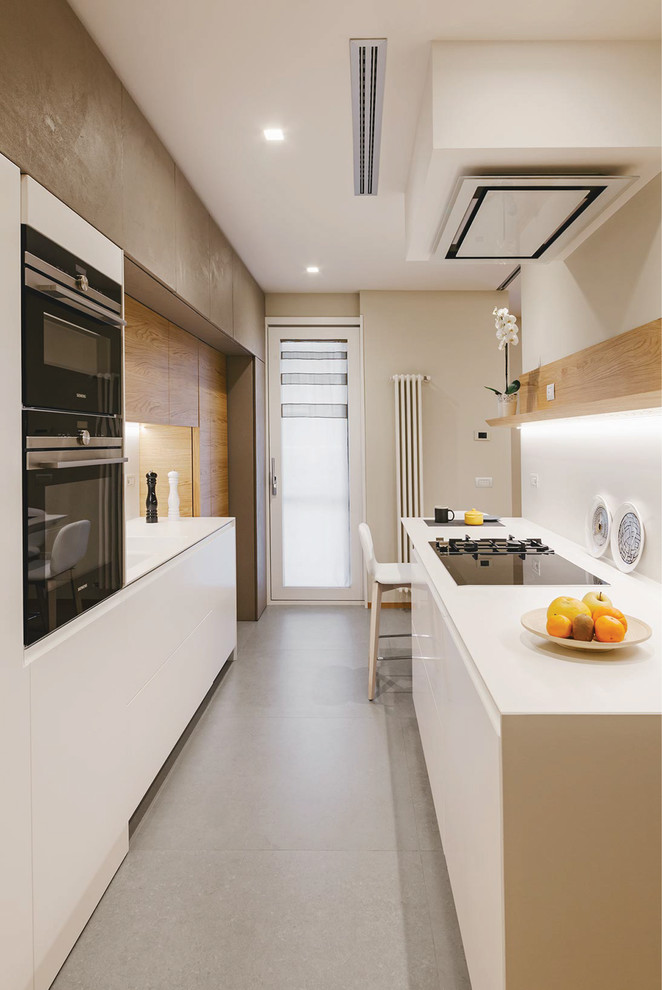 Esempio di una cucina parallela contemporanea con ante lisce, ante bianche, nessuna isola, pavimento grigio, top bianco, paraspruzzi bianco e elettrodomestici neri