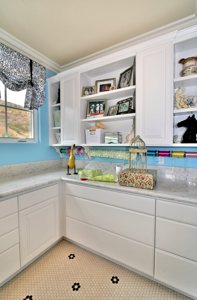 This is an example of a traditional laundry room in San Diego with white cabinets.