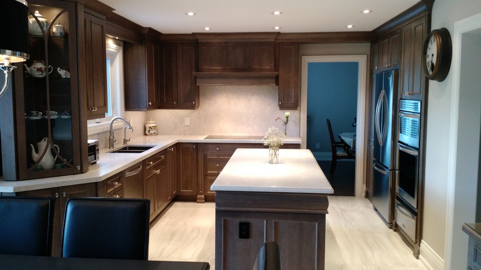Inspiration for a large transitional u-shaped porcelain tile eat-in kitchen remodel with an undermount sink, medium tone wood cabinets, solid surface countertops, stone slab backsplash, stainless steel appliances and an island