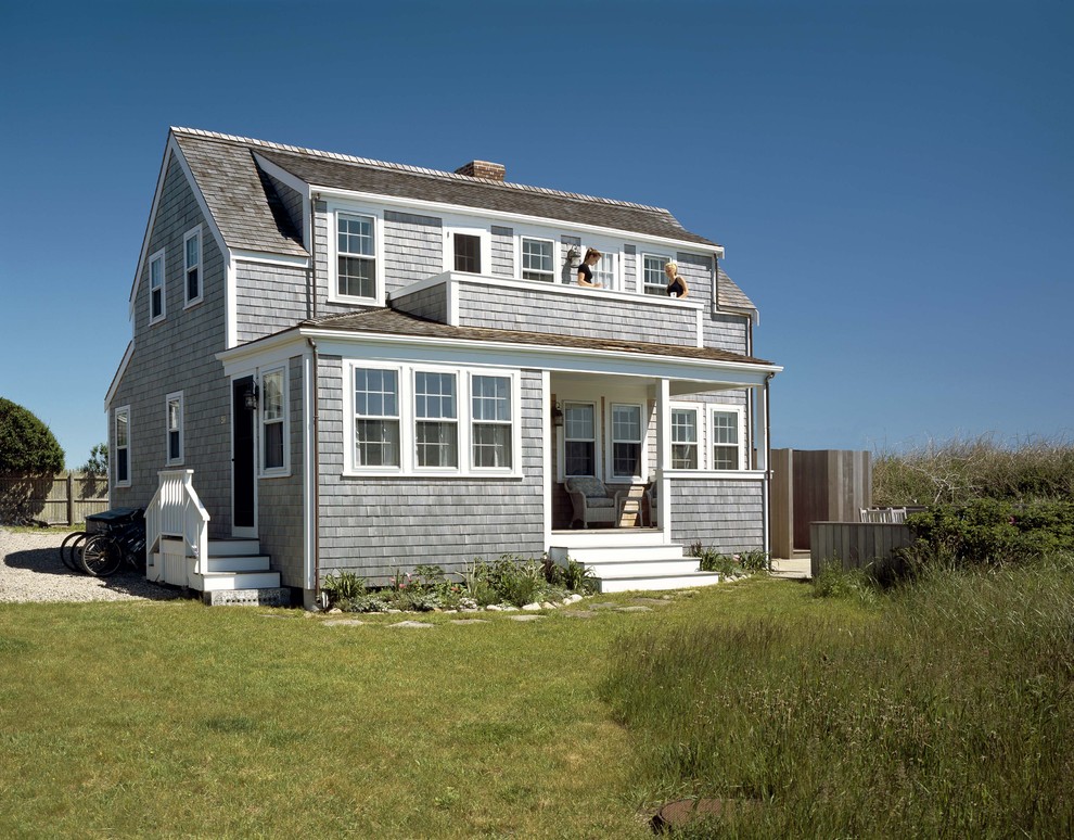 This is an example of a traditional two-storey grey exterior in Boston with wood siding and a gable roof.