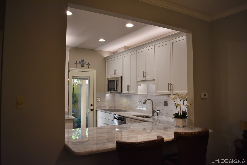 Transitional l-shaped slate floor and green floor eat-in kitchen photo with an undermount sink, shaker cabinets, white cabinets, quartzite countertops, white backsplash, glass tile backsplash, stainless steel appliances, no island and gray countertops