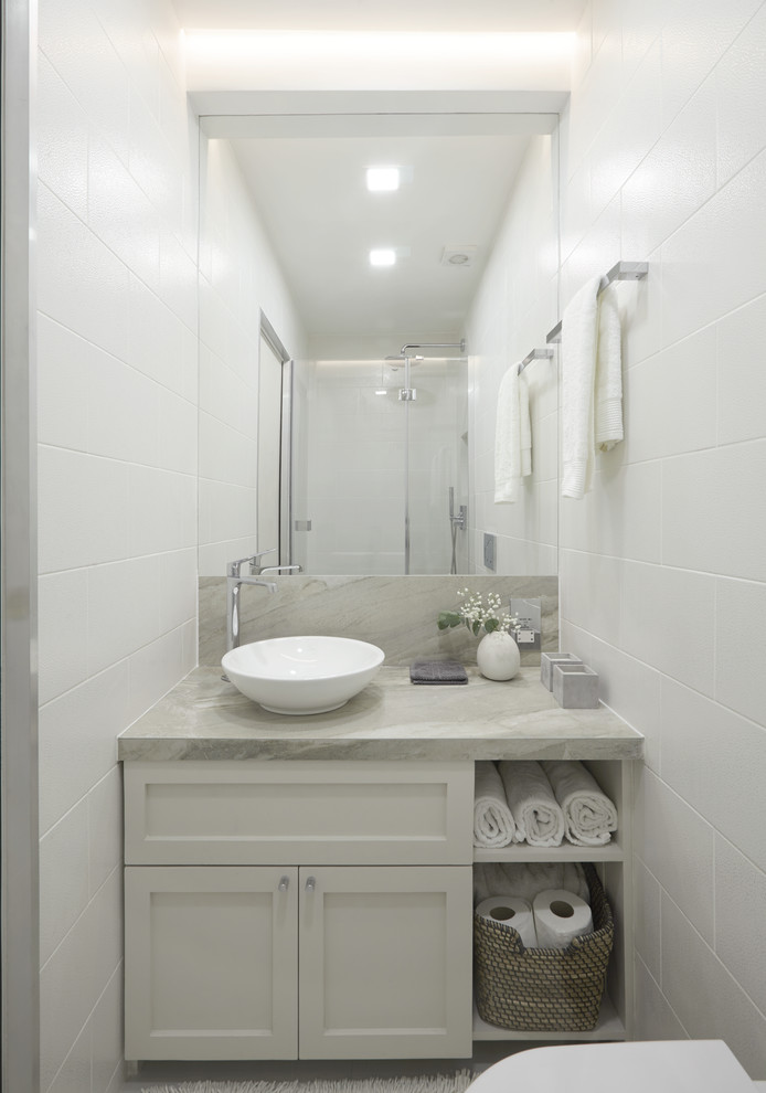 This is an example of a small transitional 3/4 bathroom in London with grey cabinets, an open shower, a wall-mount toilet, multi-coloured tile, ceramic tile, grey walls, a pedestal sink and tile benchtops.