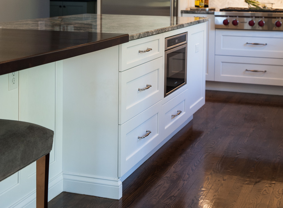 Inspiration for a mid-sized transitional l-shaped dark wood floor and brown floor kitchen pantry remodel in Boston with an island, an undermount sink, shaker cabinets, white cabinets, wood countertops, beige backsplash, marble backsplash and stainless steel appliances