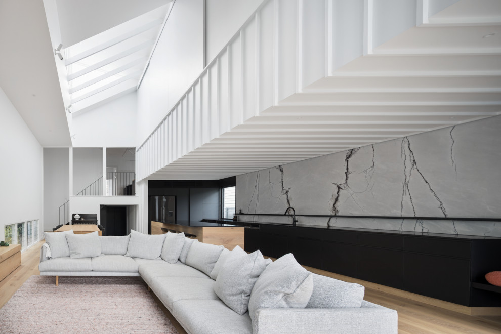 Inspiration for a large contemporary formal open concept living room in Brisbane with white walls, light hardwood floors, a standard fireplace, a concrete fireplace surround, a built-in media wall, brown floor, timber and decorative wall panelling.