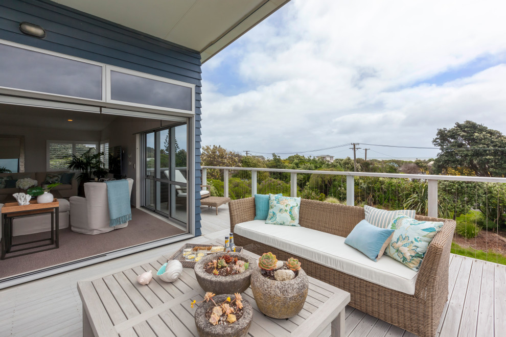 Design ideas for a large beach style balcony in Wellington with a roof extension and mixed railing.