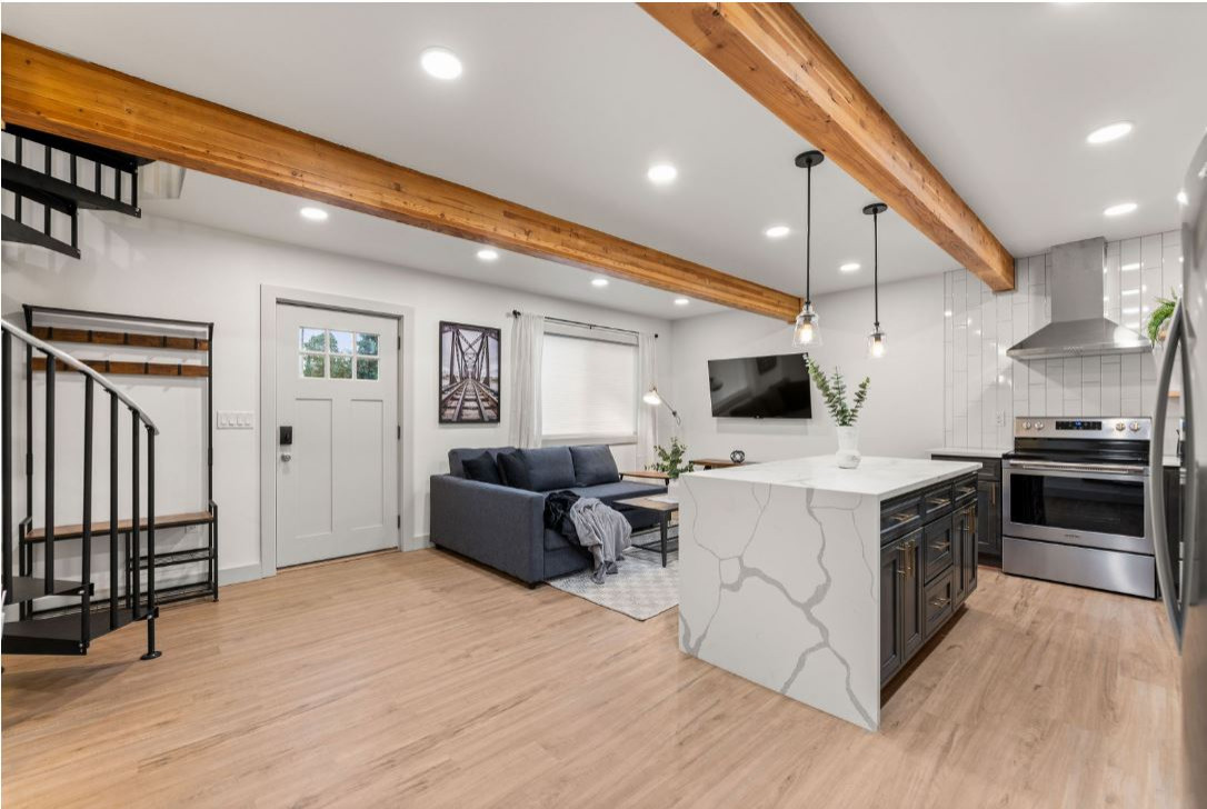 living room area with an open concept with the kitchen and bathroom, spiral staircase to the master bedroom upstairs