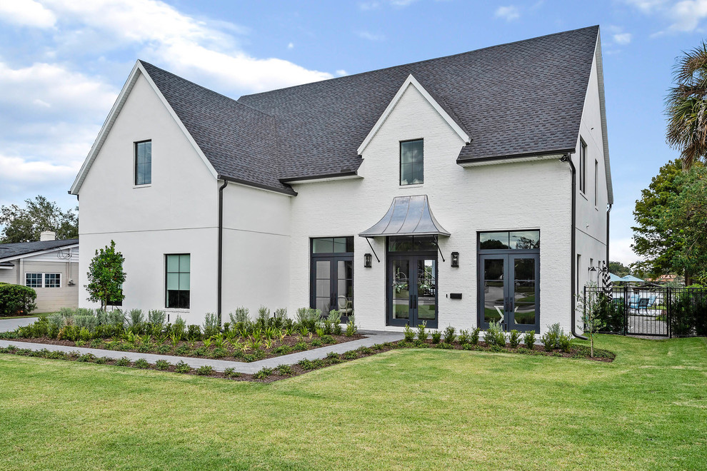 Large transitional two-storey white house exterior in Orlando with a hip roof, a shingle roof and mixed siding.