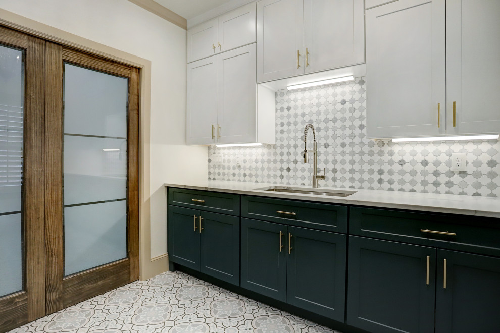 Inspiration for a large traditional galley dedicated laundry room in Houston with a drop-in sink, shaker cabinets, turquoise cabinets, quartzite benchtops, multi-coloured splashback, ceramic splashback, white walls, ceramic floors, a stacked washer and dryer, multi-coloured floor and white benchtop.