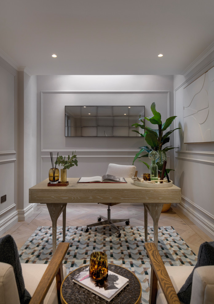 This is an example of a traditional home office in London with grey walls, medium hardwood flooring, a freestanding desk, brown floors and panelled walls.