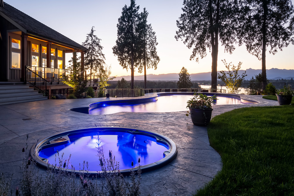 Design ideas for a large contemporary custom-shaped pool in Vancouver with stamped concrete.