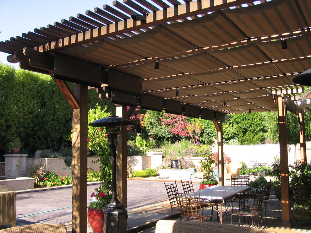 Example of a mid-sized classic backyard stone patio kitchen design in San Francisco with a pergola