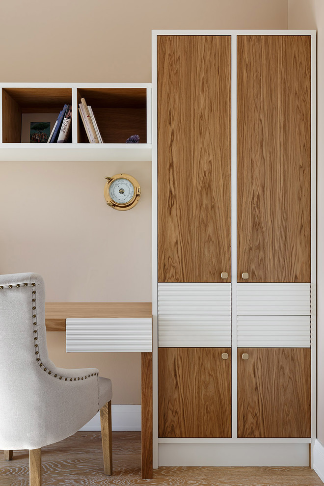 This is an example of a mid-sized transitional study room in Saint Petersburg with medium hardwood floors, a built-in desk, brown floor and beige walls.