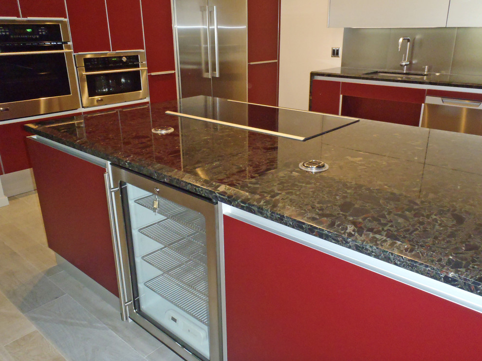 Inspiration for a contemporary l-shaped eat-in kitchen in Hawaii with an undermount sink, flat-panel cabinets, red cabinets, marble benchtops, metallic splashback, porcelain splashback and stainless steel appliances.