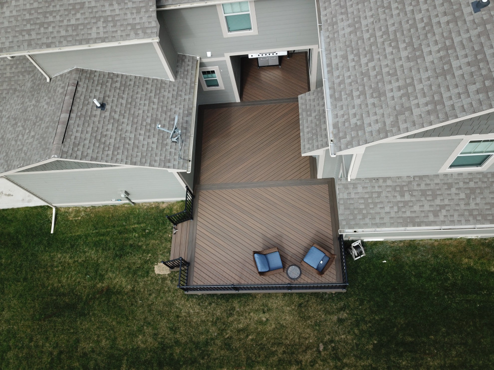 Example of a large courtyard ground level metal railing deck design with no cover